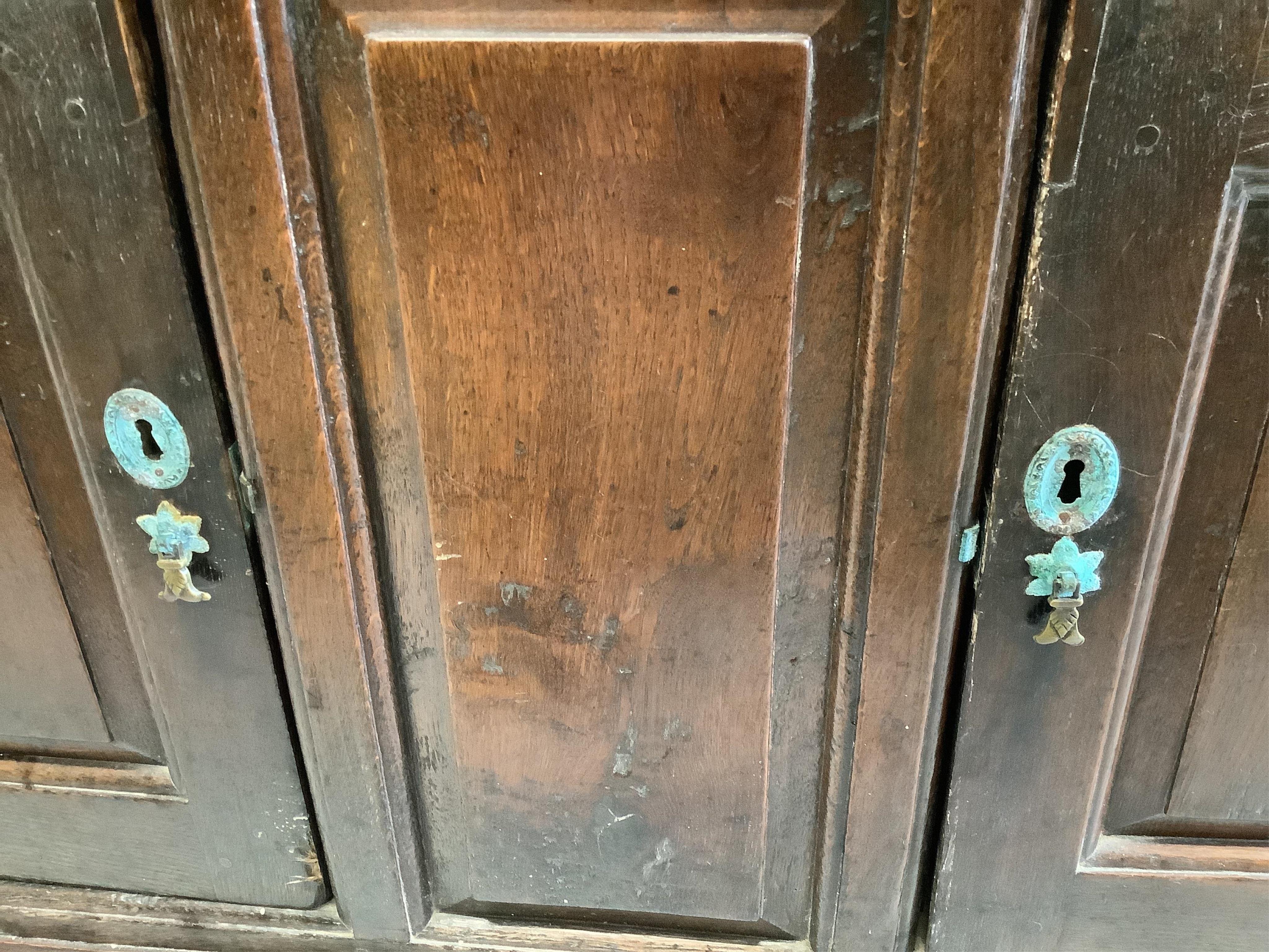 A mid 18th century oak dresser, with fielded panelled cupboards and drawers, width 143cm, depth 49cm, height 89cm. Condition - poor